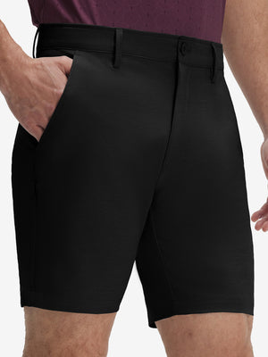 Front lower body shot of model wearing dark charcoal flat front hybrid golf shorts