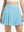 Front lower body shot of model wearing lake green women's moisture-wicking athletic tennis skirts