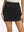 Front lower body shot of model wearing black high waist built-in short a-line golf skirt with 5 pockets