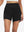 Front lower body shot of model wearing black women's high waist 2 in 1 quick dry shorts with 7 pockets