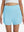 Front lower body shot of model wearing lake green women's gym golf shorts with liner pocket