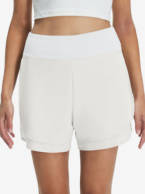 Front lower body shot of model wearing white women's gym golf shorts with liner pocket