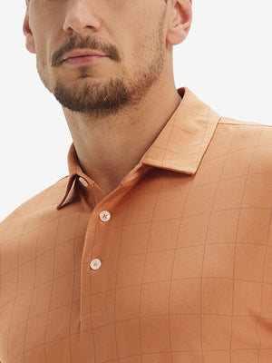 Front view from nose to chest of model wearing orange adobe reflective performance reflective checked collar golf shirt