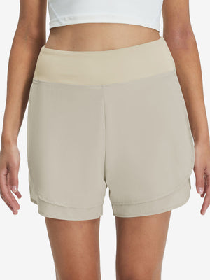 Front lower body shot of model wearing oyster gray women's gym golf shorts with liner pocket