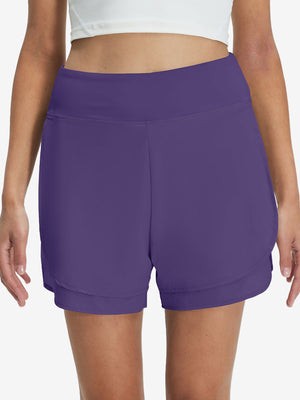 Front lower body shot of model wearing dark purple women's gym golf shorts with liner pocket
