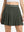 Front lower body shot of model wearing army green women's moisture-wicking athletic tennis skirts