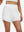 Front lower body shot of model wearing white women's high waist 2 in 1 quick dry shorts with 7 pockets