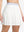 Front lower body shot of model wearing white women's moisture-wicking athletic tennis skirts