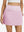 Front lower body shot of model wearing light pink women's stretch a-line golf skort with 7 pockets