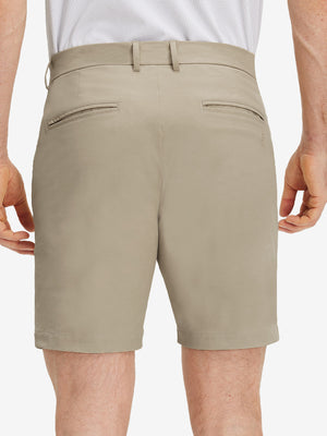 Back lower body shot of model wearing khaki grey flat front flex cotton blend golf shorts