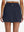 Back lower body shot of model wearing navy high waist built-in short a-line golf skirt with 5 pockets