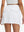 Back lower body shot of model wearing white women's stretch a-line golf skort with 7 pockets