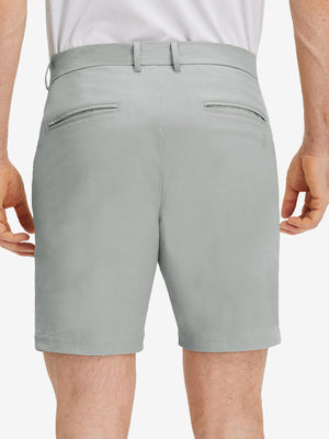 Back lower body shot of model wearing rose dust flat front flex cotton blend golf shorts