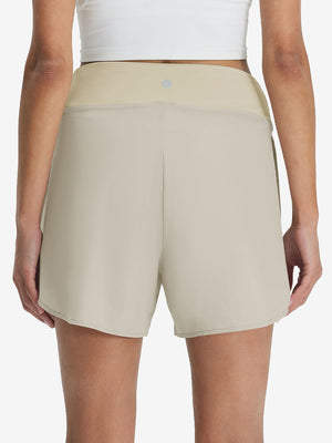 Back lower body shot of model wearing oyster gray women's gym golf shorts with liner pocket