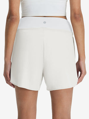 Back lower body shot of model wearing white women's gym golf shorts with liner pocket
