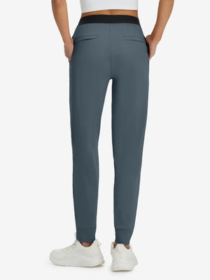 Back lower body shot of model wearing grey blue women's lightweight athletic sweatpants
