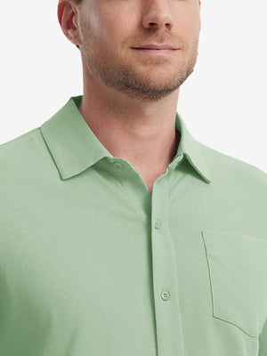 Model front view from nose to chest wearing light green cotton blend plain shirt.