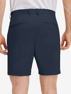 Back lower body shot of model wearing navy flat front flex cotton blend golf shorts