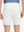 Back lower body shot of model wearing white flat front flex cotton blend golf shorts