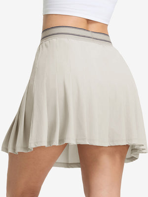 Back lower body shot of model wearing oyster gray women's moisture-wicking athletic tennis skirts