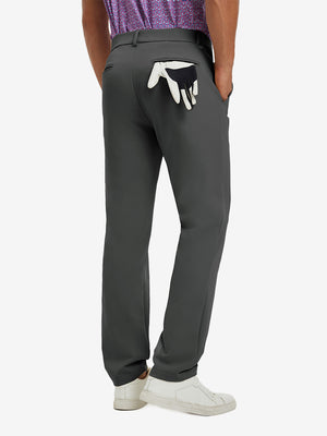 Back view of model wearing water-resistant golf stretch nylon pants, tailored stretch fit in dark grey.
