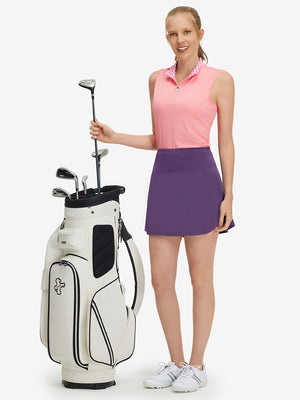 Front full body shot of model with golf gear wearing dark purple women's stretch a-line golf skort with 7 pockets