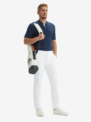 Full-body front: model in white stretch quick dry casual golf pants with 4 pocketscarrying golf bag on shoulder.