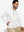 Model sitting with one hand in pocket wearing casual solid fleece hoodies pullover in white.