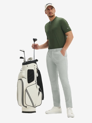 Full front view: model in light grey stretch quick dry casual golf pants with 4 pockets taking club from golf bag.