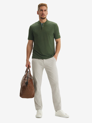Full-body front: model in light khaki stretch quick dry casual golf pants with 4 pockets carrying golf bag by hand.