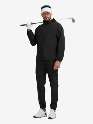 Full body shot of model playing golf in black waterproof lightweight rain jacket with hood