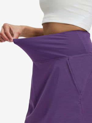 Detail view of elastic waistband on dark purple women's stretch a-line golf skort with 7 pockets