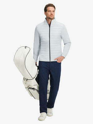 Front full body shot of model wearing light grey heather warm puffer winter golf jacket and holding a golf bag
