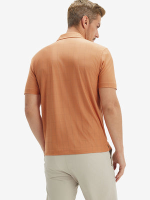 Back half body shot of model wearing orange adobe reflective performance reflective checked collar golf shirt