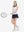 Front full body shot of model playing golf in colorful hearts women's sleeveless v-neck print golf shirts