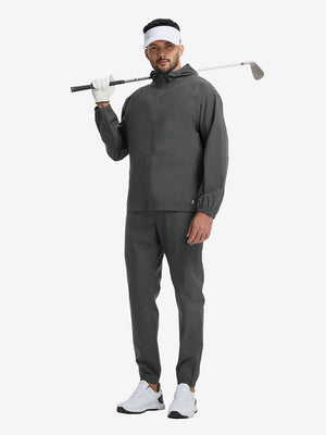 Full body shot of model playing golf in dark grey waterproof lightweight rain jacket with hood