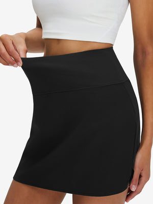 Detail view of elastic waistband on black high waist built-in short a-line golf skirt with 5 pockets