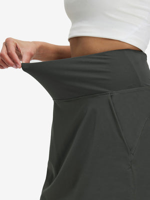 Detail view of elastic waistband on dark grey women's stretch a-line golf skort with 7 pockets
