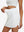Detail view of elastic waistband on white high waist built-in short a-line golf skirt with 5 pockets