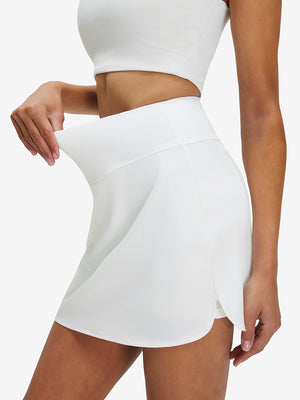 Detail view of elastic waistband on white high waist built-in short a-line golf skirt with 5 pockets