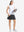 Front full body shot of model wearing white women's moisture-wicking mock neck sleeveless golf tops