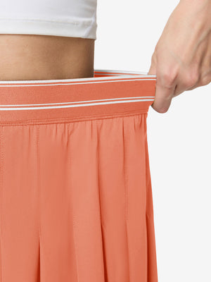 Detail view of elastic waistband on peach pink women's moisture-wicking athletic tennis skirts