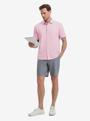 Full-body view of model holding takeaway drink cup in pink cotton blend plain shirt.