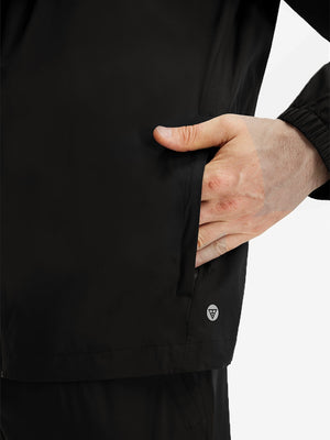 Detail view of outer pocket on  black waterproof lightweight rain jacket with hood