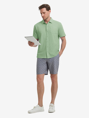 Full-body view of model holding takeaway drink cup in light green cotton blend plain shirt.