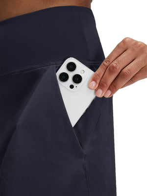 Detail view of side pocket on navy blue women's stretch a-line golf skort with 7 pockets