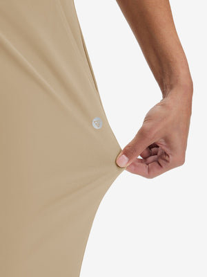View showing loose fit of light khaki women's high waist stretch golf pants with pockets