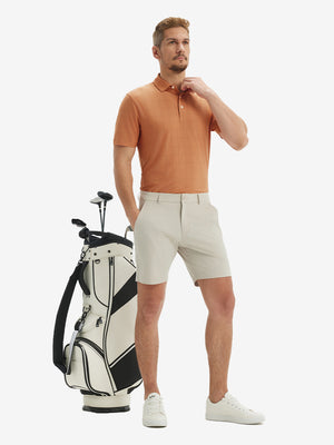 Front full body shot of model wearing orange adobe reflective performance reflective checked collar golf shirt