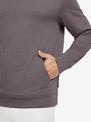 Close-up of model with both hands in pockets wearing warm fleece golf hoodies pullover dark red.