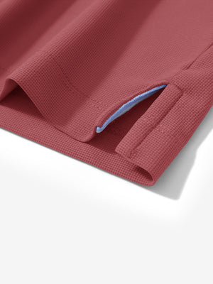 Detail view of hem on brick red dry fit waffle textured collared golf shirts